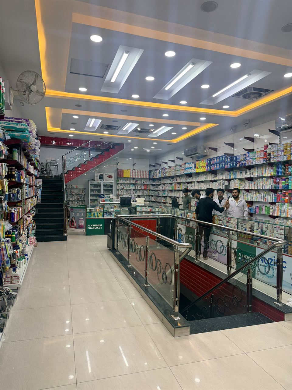 Inside Alchemist Pharmacy, staff serving customers at the counter